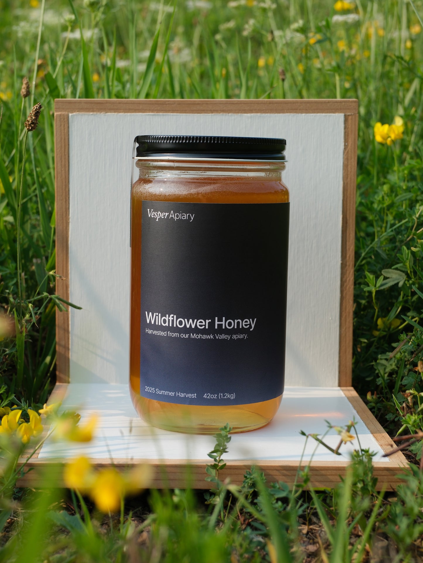 Jar of Wildflower Honey from Vesper Apiary in a white display stand with a natural background