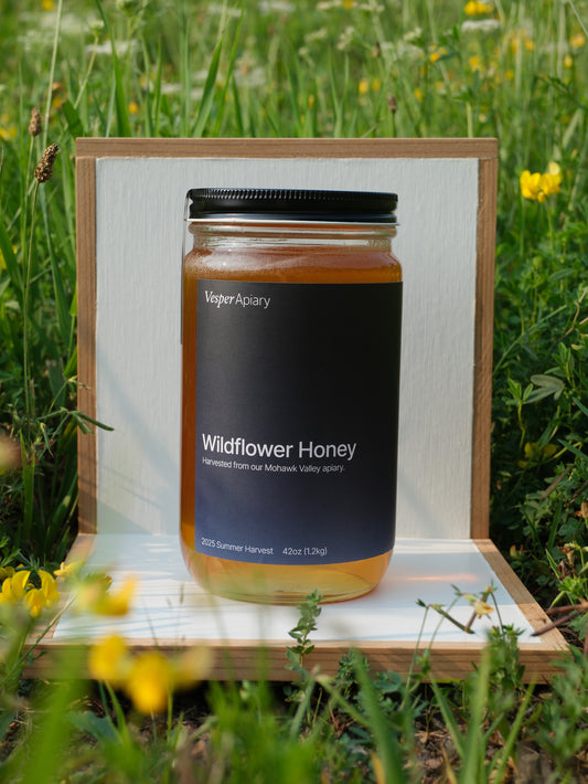 Jar of Wildflower Honey from Vesper Apiary in a white display stand with a natural background